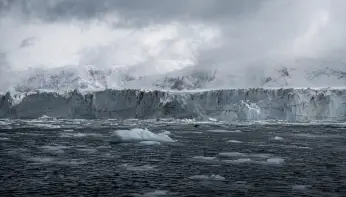 A glacier and floating sea ice under heavy cloud, representing a specialist display for a polar explorer yacht