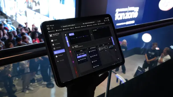 A tablet running the CanvasPro control interface, mounted on a railing above the crowd at the Atlassian Williams Racing fan zone