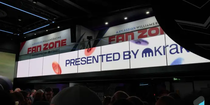 A curved LED banner reading ‘Atlassian Williams Racing Fan Zone, presented by Kraken’ above a crowd